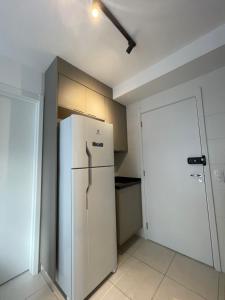 a kitchen with a white refrigerator and a door at Apto Completo na Chac Sto Antonio 7 min do Vibra SP in Sao Paulo