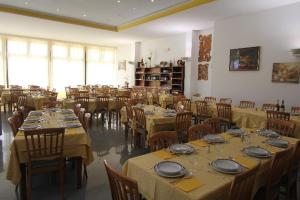 una grande sala da pranzo con tavoli e sedie con piatti di Hotel Liliana Andora citr 9006-0004 a Marina dʼAndora