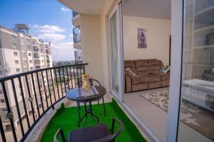 Cette chambre dispose d'un balcon avec une table et un canapé. dans l'établissement Fahrenheit Homes, à Nairobi