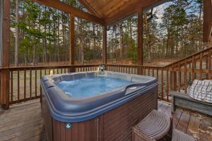 a hot tub on the deck of a house at NEW Prime Cabin Hot Tub-Firepit-Safari Sleeps 8 in Broken Bow