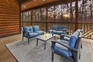 a porch with wicker chairs and a table on a deck at NEW Prime Cabin Hot Tub-Firepit-Safari Sleeps 8 in Broken Bow