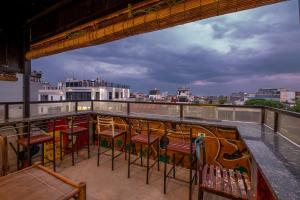 a balcony with chairs and tables on a roof at Hanoi Central Pod in Hanoi