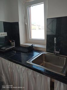 a kitchen counter with a sink and a window at ''RENATA'' Studio in Kithnos