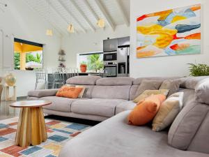 a living room with two couches and a table at Villa Jardin secret de la boucan - OFFRE SAISONNIERE ! in Sainte-Rose