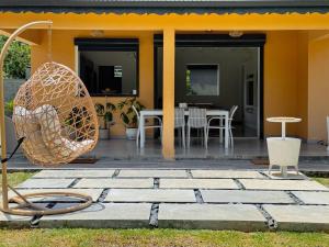 a house with a patio with a swing at Villa Jardin secret de la boucan - OFFRE SAISONNIERE ! in Sainte-Rose +37 photos