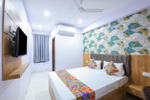 a hotel room with a bed and a tv at FabHotel Golden Comforts - Near Shivaji Nagar in Bengaluru