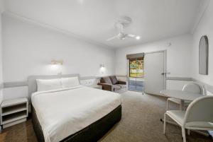 纳甘比Centre Town Motel的一间卧室，配有一张床、一张桌子和几把椅子 更多15张照片