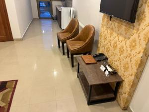 a waiting room with three chairs and a table at amlak Resorts Apartment Suite Bhurban in Bhurban +2 photos