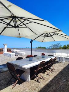 un tavolo con sedie e un grande ombrellone di Villa Castrignano a Monopoli