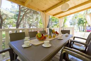 einen blauen Tisch mit einer Schale Obst auf einer Veranda in der Unterkunft Quality Mobile Homes in Camping Kazela in Medulin