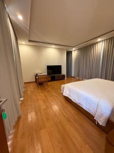 a bedroom with a bed and a flat screen tv at Avela bali villa in Kerobokan