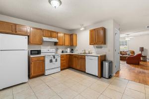 a kitchen with wooden cabinets and white appliances at Spacious 3BR Retreat Perfect for Groups Near Downtown in Raleigh