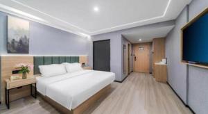 Ένα ή περισσότερα κρεβάτια σε δωμάτιο στο GreenTree Inn Taizhou Gaogang District Business Hotel