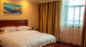 Ένα ή περισσότερα κρεβάτια σε δωμάτιο στο GreenTree Inn Wuhu Fangte Second Phase Nanxiang Wanshang Express Hotel