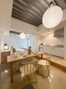 a dining room with a table and chairs and a kitchen at b hotel Arts Dobashi - Calm Studio Stay Steps to Peace Park in Hiroshima