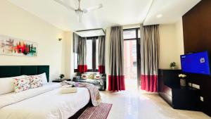 a bedroom with a bed and a tv in a room at Olive Service Apartments - Greater Kailash in New Delhi +19 photos