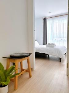 ein Schlafzimmer mit einem Bett und einem Tisch und einem Bett sidx sidx sidx in der Unterkunft Wonderful Stay BTS Ratchayothin in Bangkok