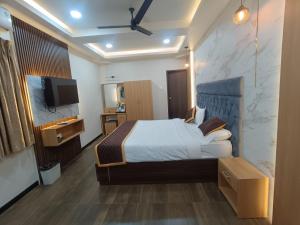ein Schlafzimmer mit einem Bett und einem Flachbildfernseher in der Unterkunft Green Palace Inn, T Nagar in Chennai