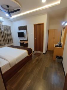 ein Hotelzimmer mit einem Bett und einem Fernseher in der Unterkunft Green Palace Inn, T Nagar in Chennai