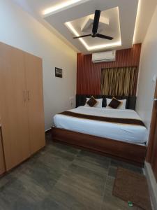 Schlafzimmer mit einem Bett und einem Deckenventilator in der Unterkunft Green Palace Inn, T Nagar in Chennai