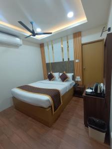 ein Schlafzimmer mit einem großen Bett und einem Deckenventilator in der Unterkunft Green Palace Inn, T Nagar in Chennai