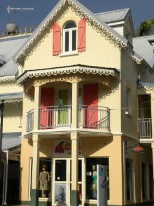 a large yellow building with red doors and windows at CoCoKreyol - " GRENADINE " in Les Trois-Îlets