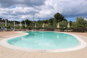 a large swimming pool with chairs and umbrellas at Residence Rendez Vous in Vieste