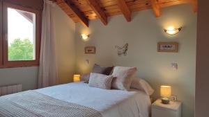 a bedroom with a white bed with a window at Cozy Home Ajo, Hogar Cerca del Mar in Bareyo