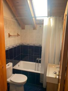 a bathroom with a toilet and a tub and a sink at Cozy Home Ajo, Hogar Cerca del Mar in Bareyo +24 photos