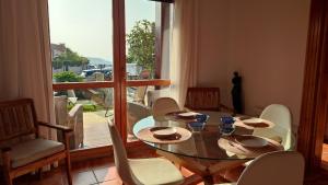 a dining room with a glass table and chairs at Cozy Home Ajo, Hogar Cerca del Mar in Bareyo