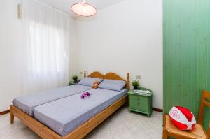 Un dormitorio con una cama y una mesa con flores. en Condominio Brionetta, en Bibione
