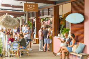 バイロンベイにあるByron Bay Beachfront Holiday Apartment - Pool, Ocean Views, 3 Bedrooms, Family & Group Accommodationの店外に立ち並ぶ人々 +18枚の写真