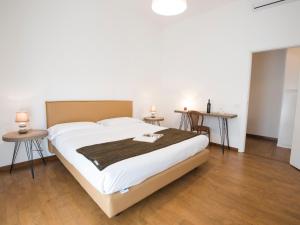 Un dormitorio con una cama grande y dos mesas. en Italianflat - Palazzo Rizzardi, en Verona
