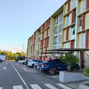 ein Parkplatz mit vor einem Gebäude geparkten Autos in der Unterkunft Refugio Custodia 2 vista a montaña in Tarapoto