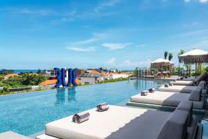 a pool at a resort with chaise lounges at TUI BLUE Berawa Hotel and Villas in Canggu
