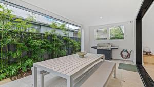 een patio met een witte tafel en een fornuis bij Beach Retreat By Bode in Hawks Nest