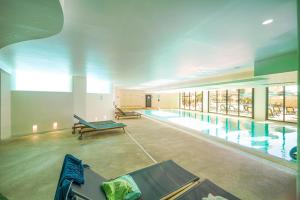 a large swimming pool with benches in a building at Estrela Apartment by Moje Holiday in Luz