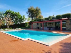 a swimming pool with a patio and a house at Leopoldina L'Orto in Arezzo