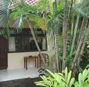 a room with a table and some palm trees at Rach APT in Kerobokan +3 photos