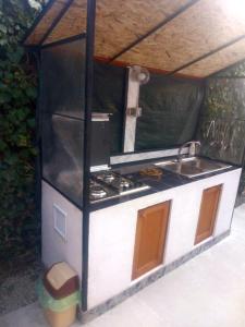 Una pequeña cocina con fregadero y estufa. en Casa Dorului, en Mangalia