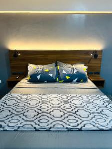 a bed with blue and white sheets and pillows at Traveler's Nest near Airport, Netflix, Stylish, Cozy with swimming pool in Lapu Lapu City +19 photos