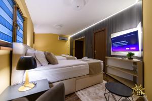 a hotel room with a large bed and a flat screen tv at Vodenica 3 Rooms in Duračka Reka