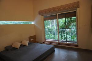 a bedroom with a bed and a large window at Malhar - Your home away from home in Bālūssheri +5 photos