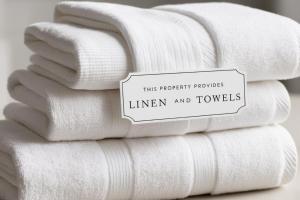 a stack of towels with a sign that reads this propertylords linen and towels at Cowes Rest n Relax in Cowes +8 photos
