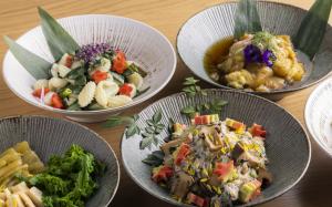 a table with four bowls of food on it at Hilton Kyoto in Kyoto
