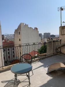 a table and a chair on a balcony with a view at Hôtel Le Capitol in Marseille
