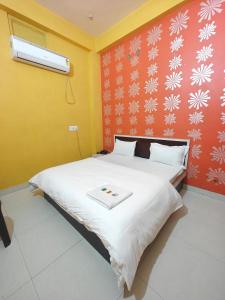 a bedroom with a large bed with a white blanket at Hotel Pink City in Sīkar