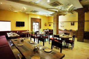 a dining room with tables and chairs in a restaurant at hotel sandhu palace in Jodhpur