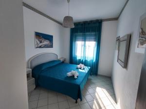 a small bedroom with a blue bed and a window at Case Vacanza Punta Bianca in Agrigento