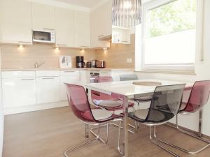 a kitchen with a table and pink chairs at Ferienhaus Hanni in Schillig